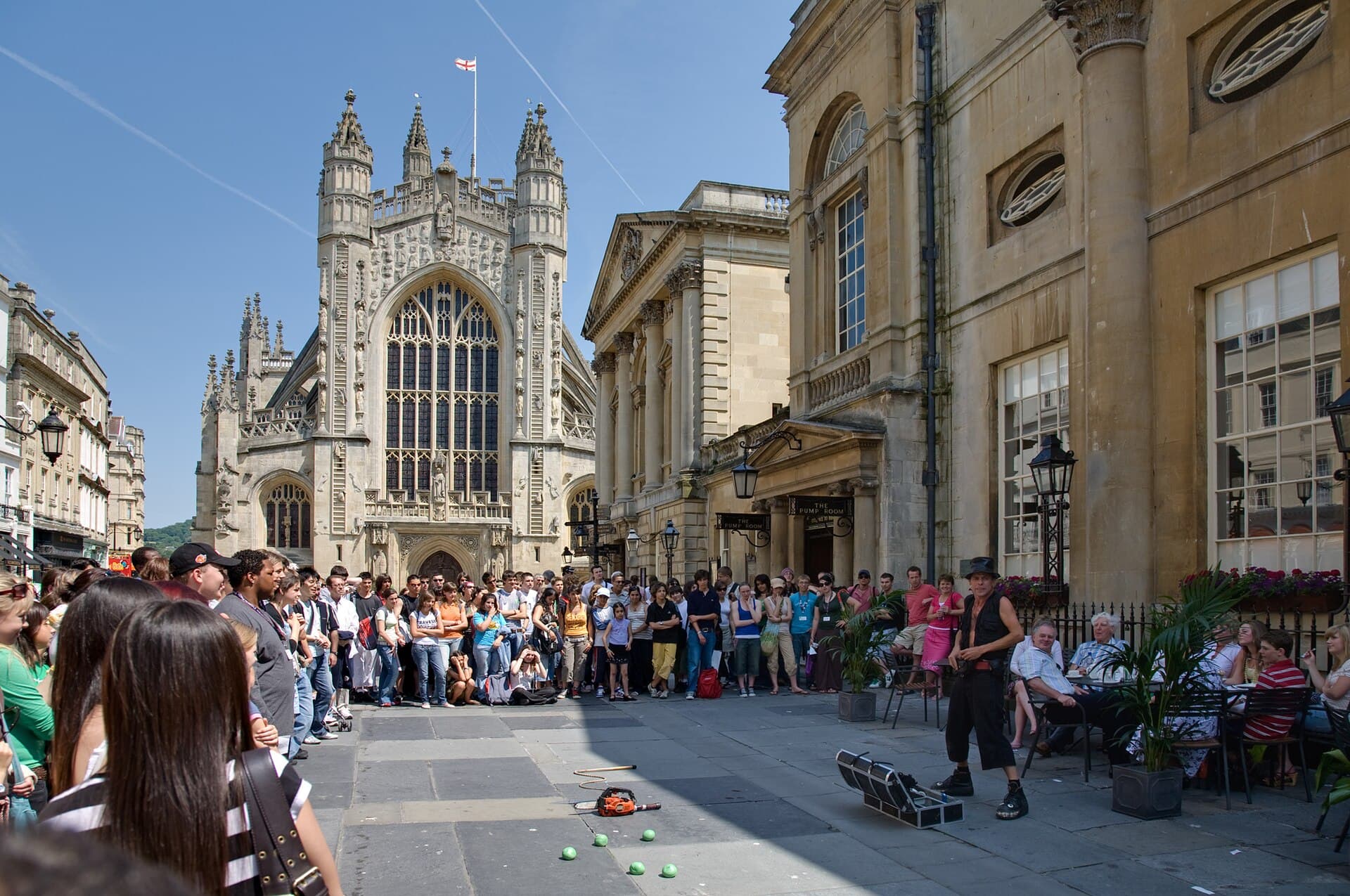 Bath Abbey and Entertainer. Bath is very popular with tourists, particularly in the summer, and the city bustles with life. An entertainer performs for the crowd in front of the Bath Abbey and to the right, the Roman Baths. Taken by myself with a Canon 5D and 24-105mm f/4L IS lens.